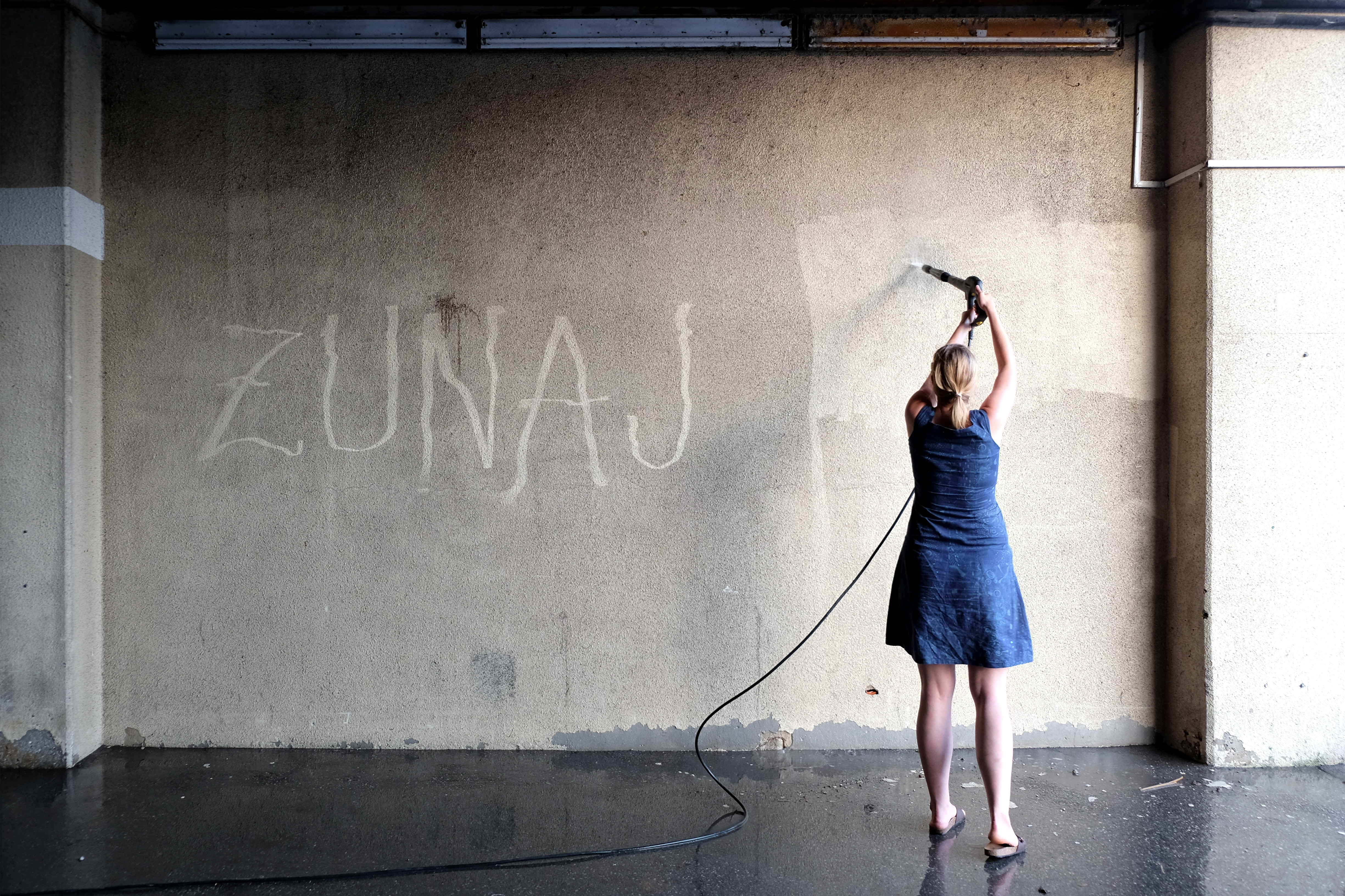 stena z napisom Zunaj, poleg ženska, ki čisti steno