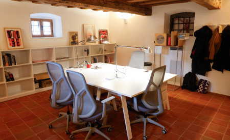 miza sredi prostora, okoli nje stoli