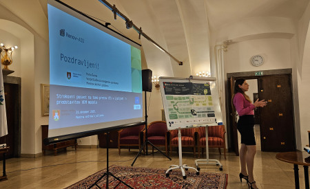 predavateljica stoji in govori, v ozadju zaslon