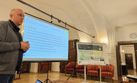 predavatelj stoji pred zaslonom 