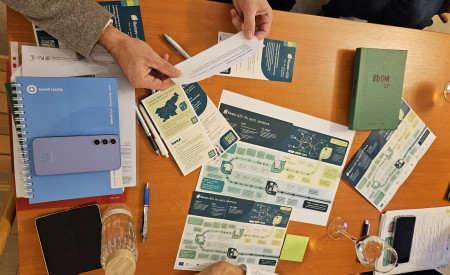 pogled na mizo, na kateri so papirji, zvezki, telefoni...