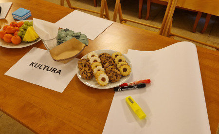 miza, na njej piškoti in sadje ter napis KULTURA