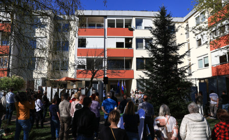 ljudje stojijo pred blokom