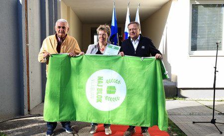 župan in predstavnika bloka v rokah držijo zastavo Naj blok