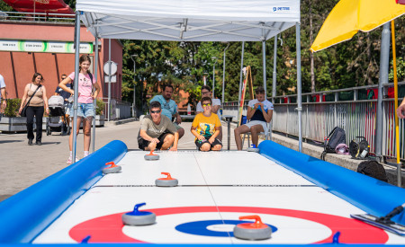 Obiskovalci festivala igrajo curling 
