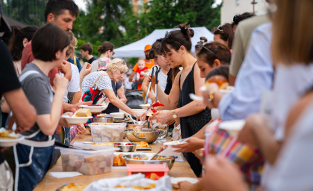 ljudje se družijo ob mizi, na kateri so različne vrste hrane