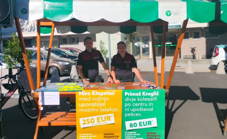 redarja stojita za stojnico, v ospredju so ozaveščevalni plakati