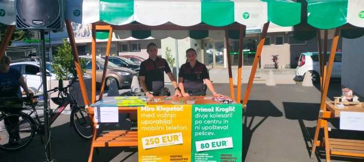 Mestna redarja stojita ob stojnici s plakati Mestnega redarstva