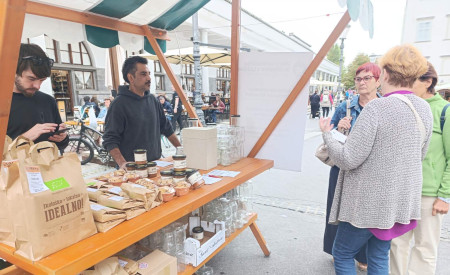 stojinca na Pogačarjevem trgu, pred katero stojijo tri ženske