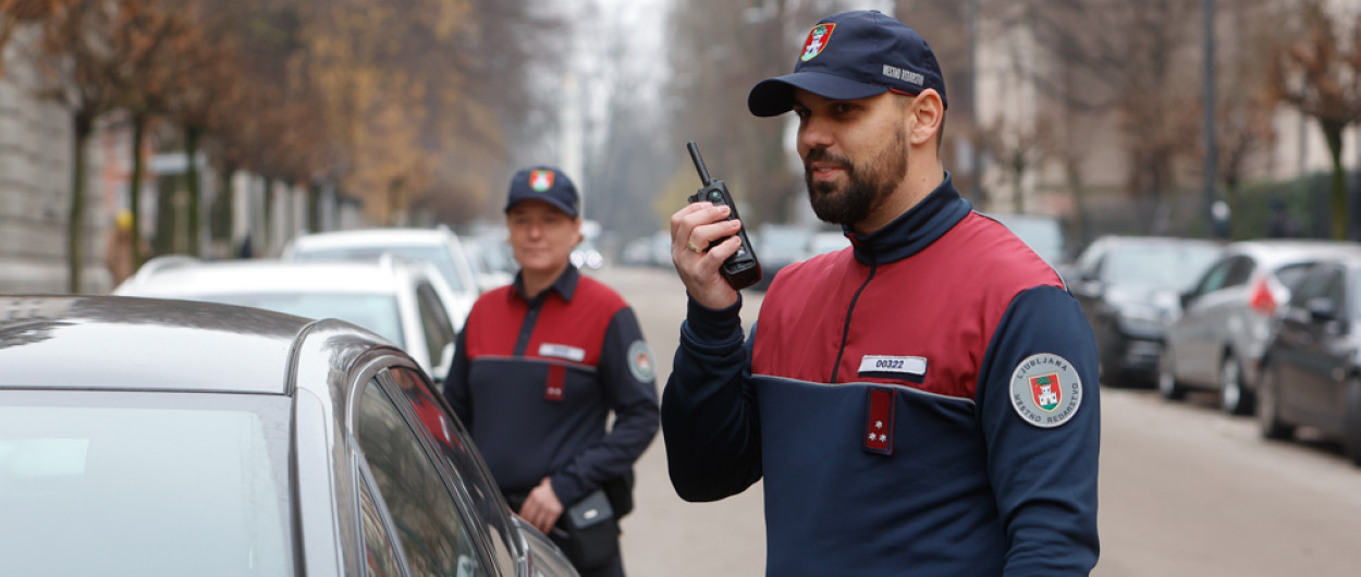 mestni redar stoji ob avtu