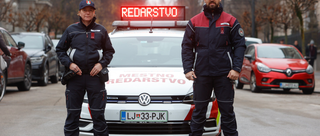 redarja stojita pred službenim vozilom