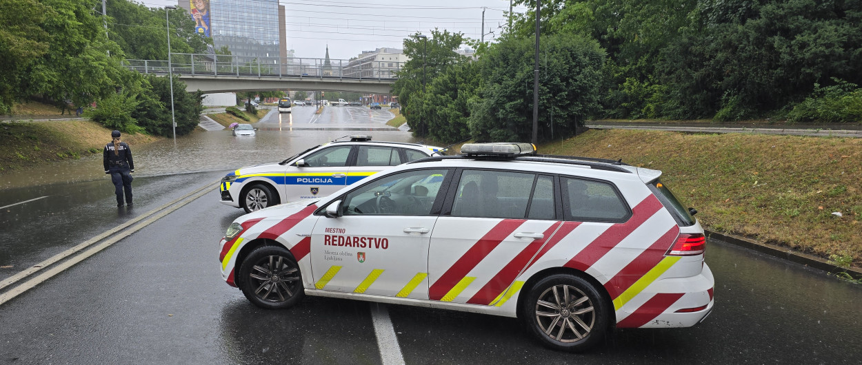 vozila mestnega redarstva ob poplavljenem podvozu
