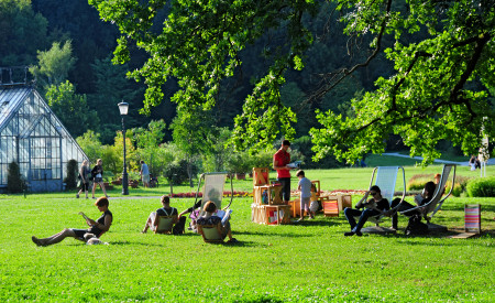 Knjižnica pod krošnjami z rastlinjakom v ozadju, foto: D. Wedam, vir Turizem Ljubljana