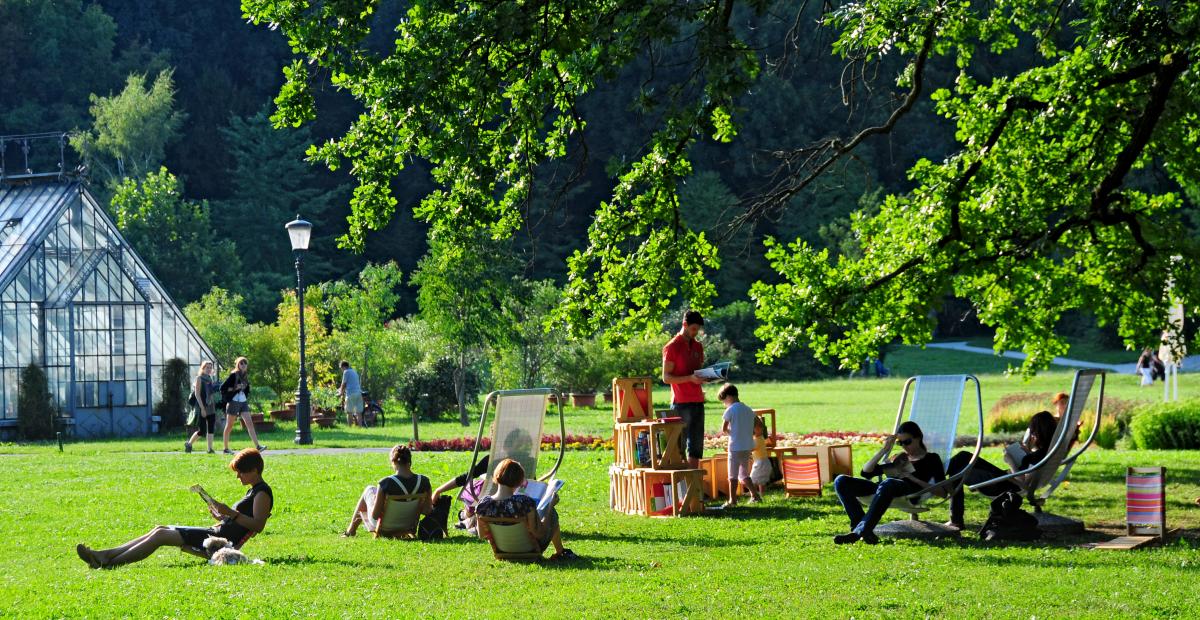 Knjižnica pod krošnjami z rastlinjakom v ozadju, foto: D. Wedam, vir Turizem Ljubljana