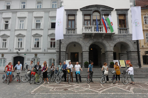zastava in kolesarji pred Mestno hišo