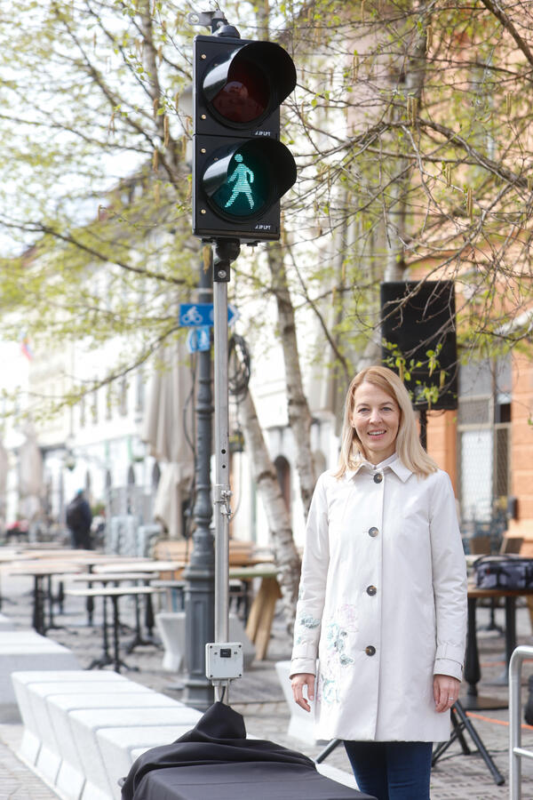 Podžupanja Tjaša Ficko ob semaforju z žensko podobo za pešce. Foto: N. Rovan
