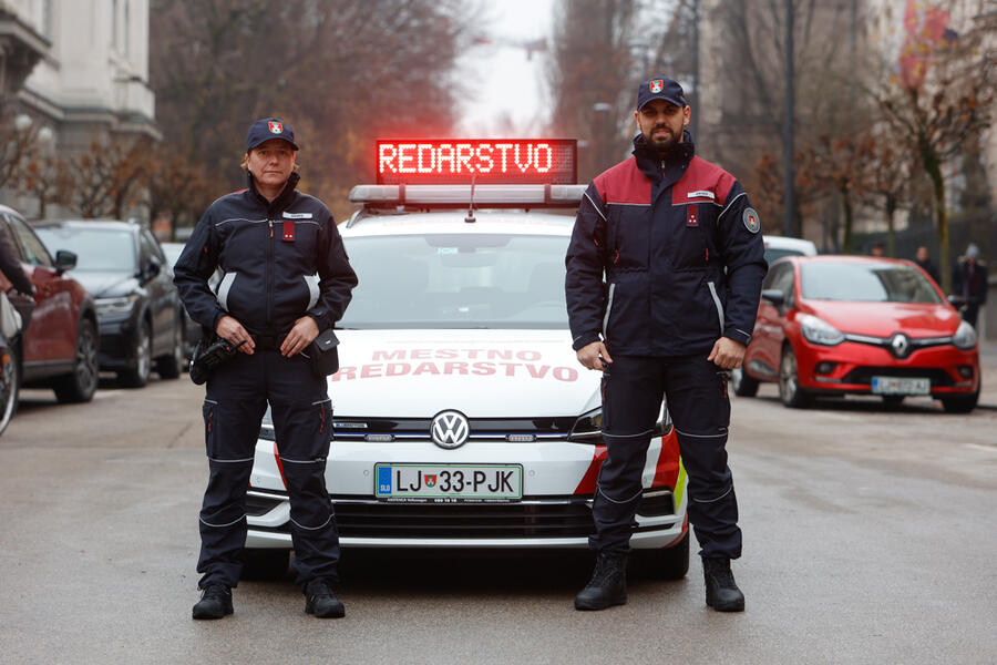 redarja stojita pred službenim vozilom