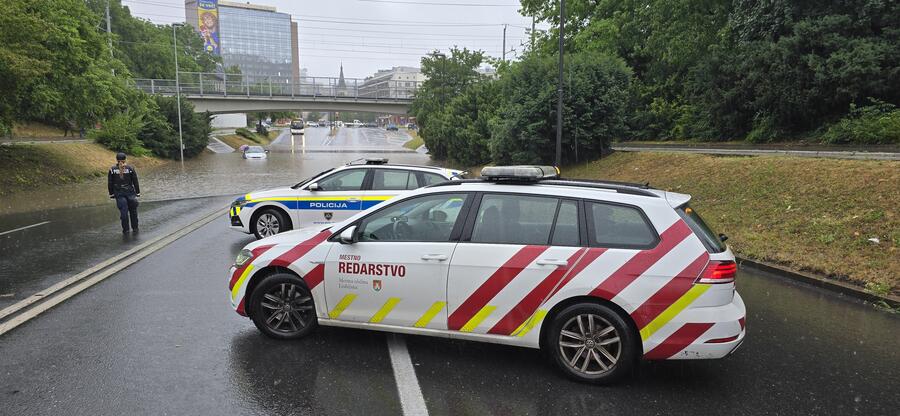 vozila mestnega redarstva ob poplavljenem podvozu