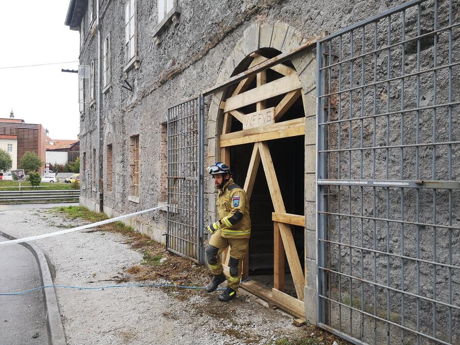 gasilec stopa iz delno porušene zgradbe