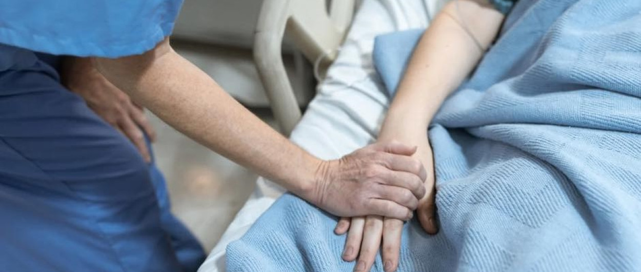 Medicinska sestra drži pacientko za roko, foto vir: ZD Ljubljana