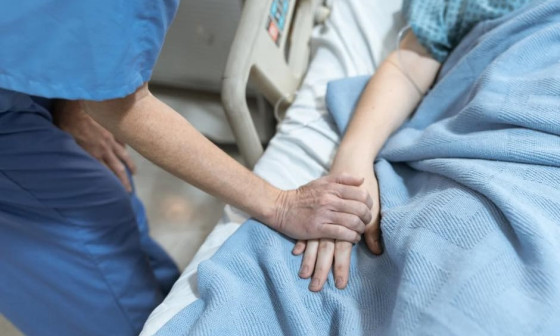 Medicinska sestra drži pacientko za roko, foto vir: ZD Ljubljana