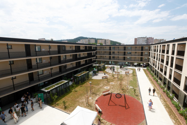 pogled na zelenico in otroško igrišče med bloki